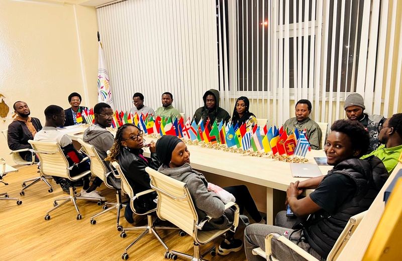 Réunion d'étudiants africains autour d'une table avec des drapeaux